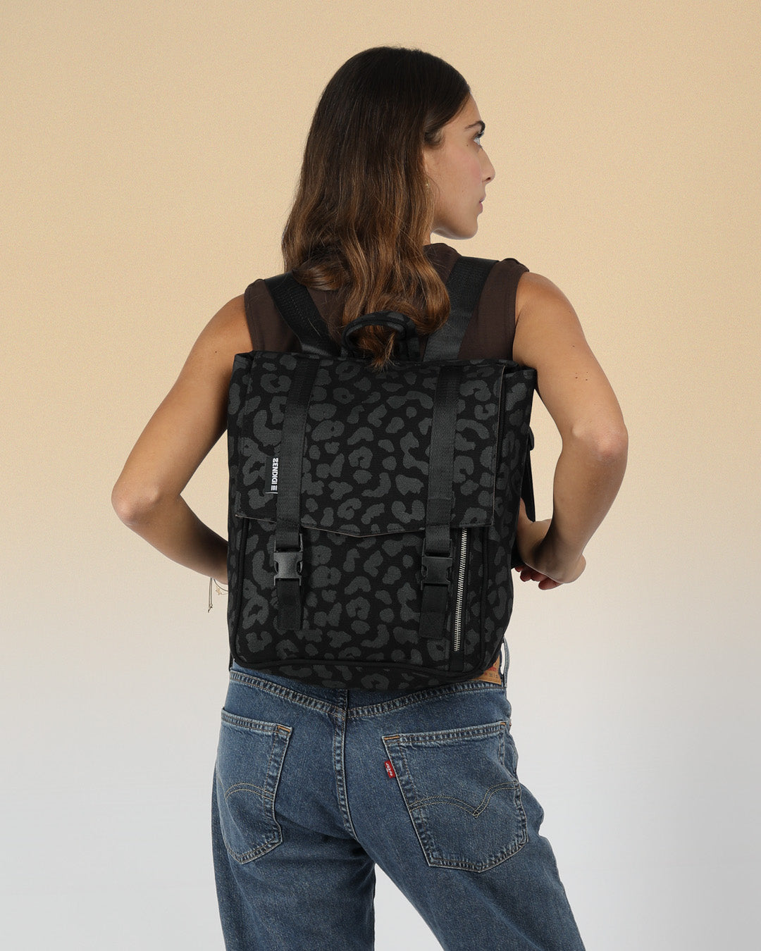 תיק גב מנומר שחור למחשב נייד קטן על דוגמנית, עיצוב ישראלי, תיק איכותי שנשמר לשנים, הדפסה ידנית, תיק גב היסטרי