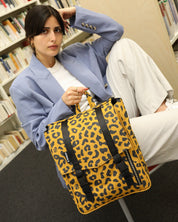 סטודנטית מחזיקה ביד תיק גב מיני טוקיו מנומר קלאסי של זנדיגי, הדפס שהם עושים בעצם בסטודיו, התיק הוא תיק גב ללימודים, למשרד או לעבודה.