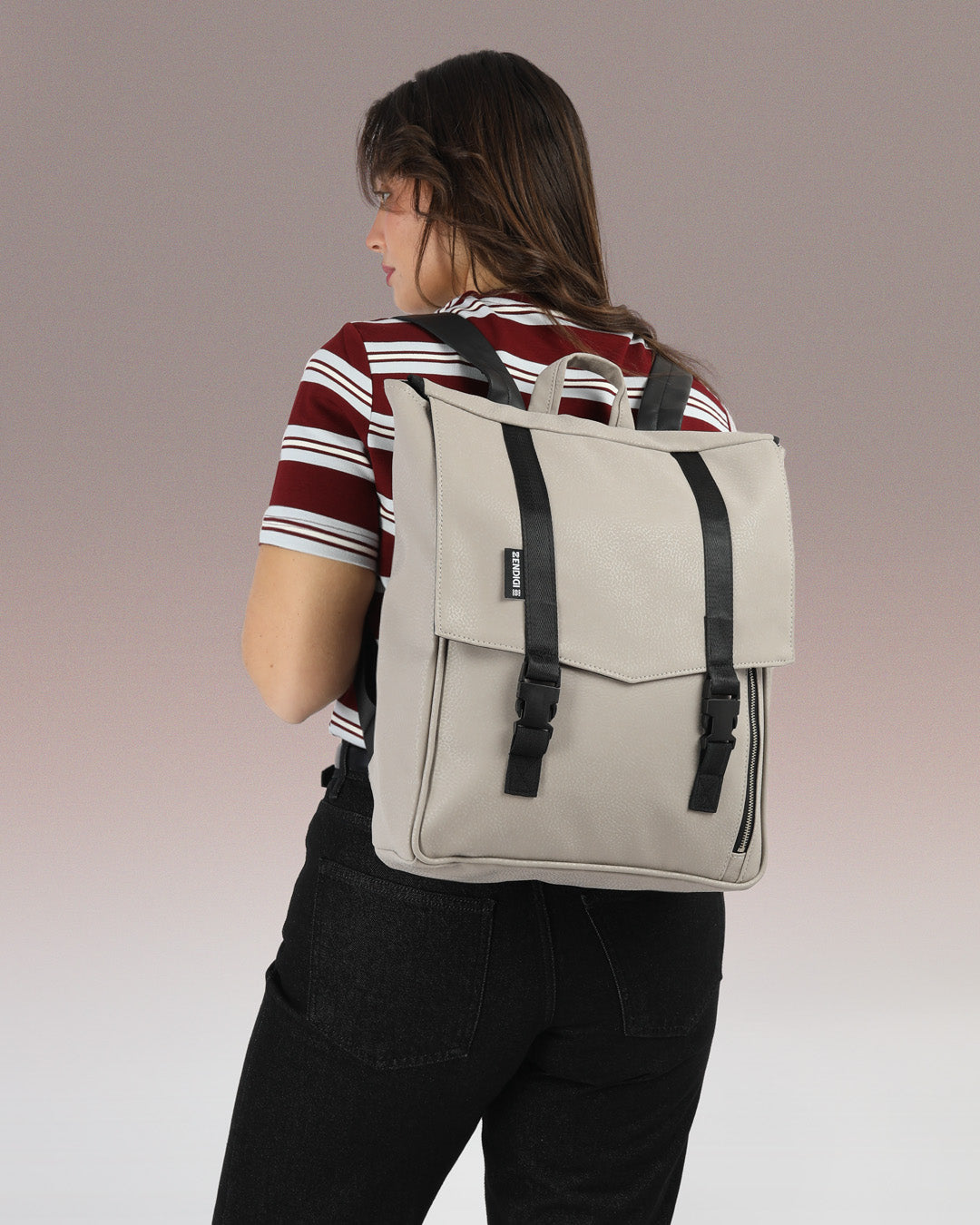 תיק גב טוקיו בצבע אבן זמש על גב של דוגמנית, תיק טבעוני עם עיצוב פרקטי ומוקפד, מתאים לגבר ולאישה.