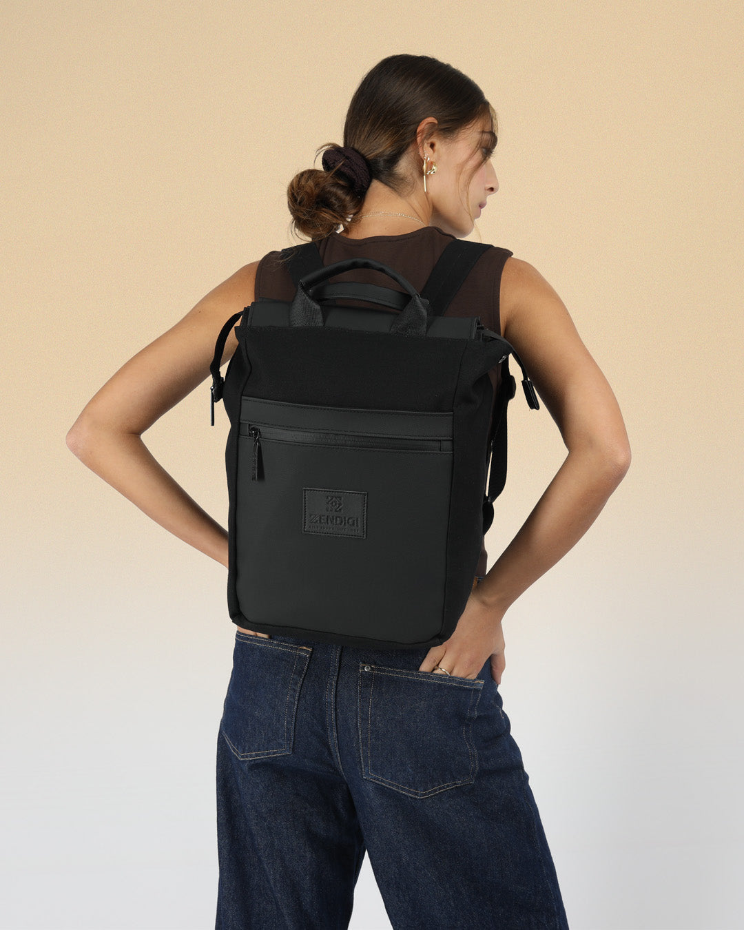 תיק גב מיני מילאנו בצבע שחור, תיק למחשב עד 14״ על גב של דוגמנית, תיק מרופד למחשב נייד תיק גב ללפטופ, מושלם ללימודים ולעבודה, תיק לסטודנטים, תיק גב מעוצב לאישה ולגבר