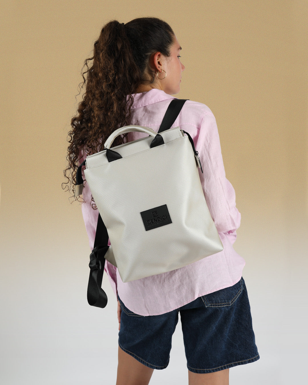 מבט מאחור על דוגמנית הלובשת תיק גב ברלין כסף שיבולים למחשב נייד, עם רצועות גב שחורות מתכווננות לנוחות מקסימלית.