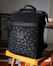 תקריב על תיק גב מרופד למחשב מדגם מילאנו עם הדפס מנומר שחור, מציג את רצועות האחיזה העליונות והרוכסנים האיכותיים