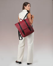 תיק גב טוקיו צבע אדום דובדבן – תיק לנשים, גברים ולסטודנטים עם מקום ללפטופ עד 16 אינץ', סגנון אורבני מינימליסטי, איכותי ועמיד למים מוצג על דוגמנית