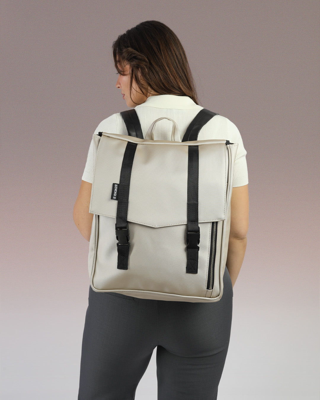 דוגמנית עם תיק גב טוקיו בכסף שיבולים מבית זנדיגי - תיק גב טבעוני למחשב נייד בעיצוב מינימליסטי ונקי, מושלם לסטודנטים ולהייטקיסטים.