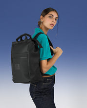 תיק גב למחשב שחור עם טקסטורת יהלומים, תיק לפטופ ללימודים באוניברסיטה, תיק לסטודנטים, על דוגמנית עם רצועה אחת על הכתף, ניתן לראות את הפרופורציות של התיק על הדוגמנית ואת הטקסטורה שלו.