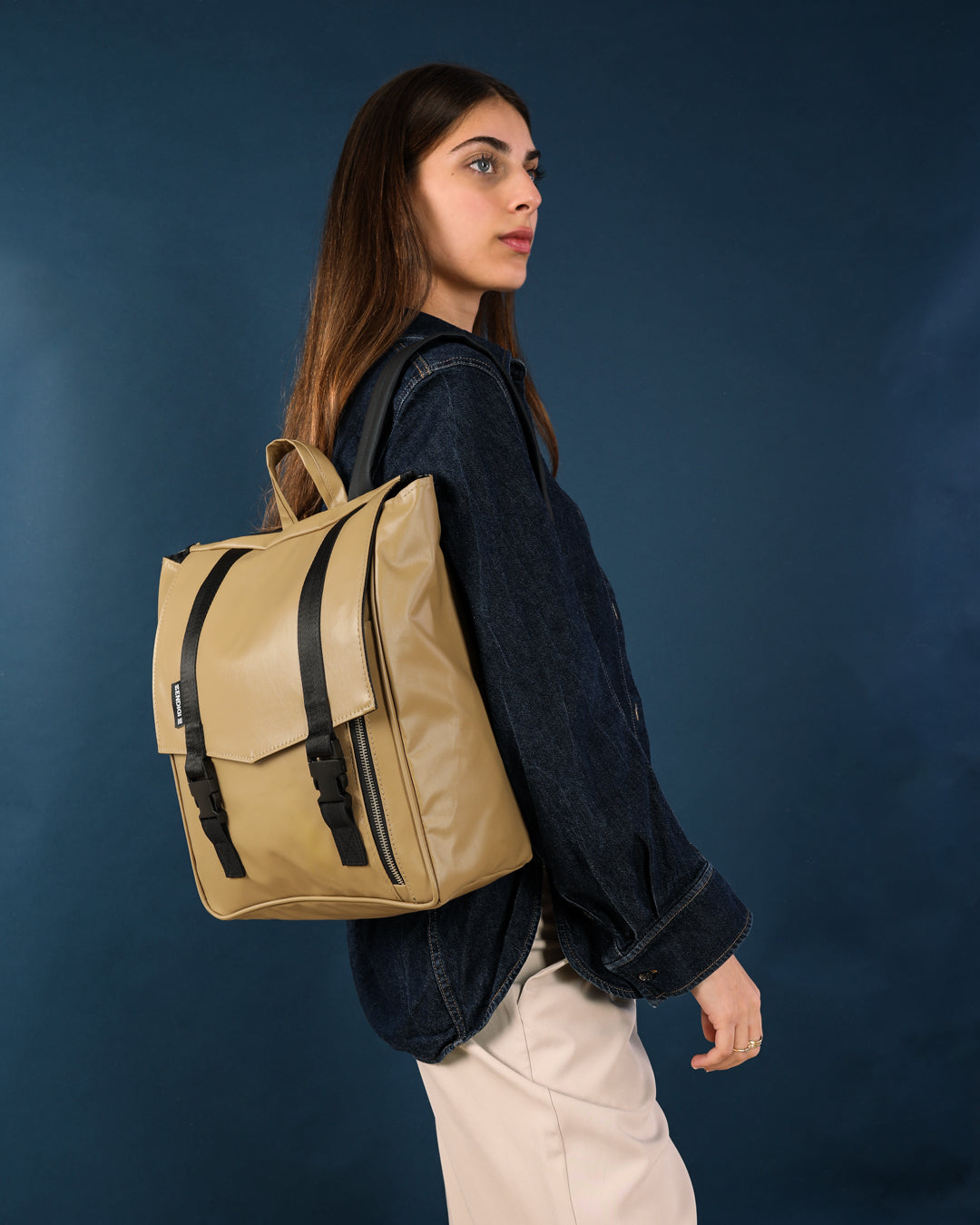 תיק גב מינימליסטי למחשב נייד בצבע קפה, עשוי מחומרים טבעוניים עמידים, שילוב מושלם בין תיק אופנתי לתיק לימודים פרקטי לאוניברסיטה.