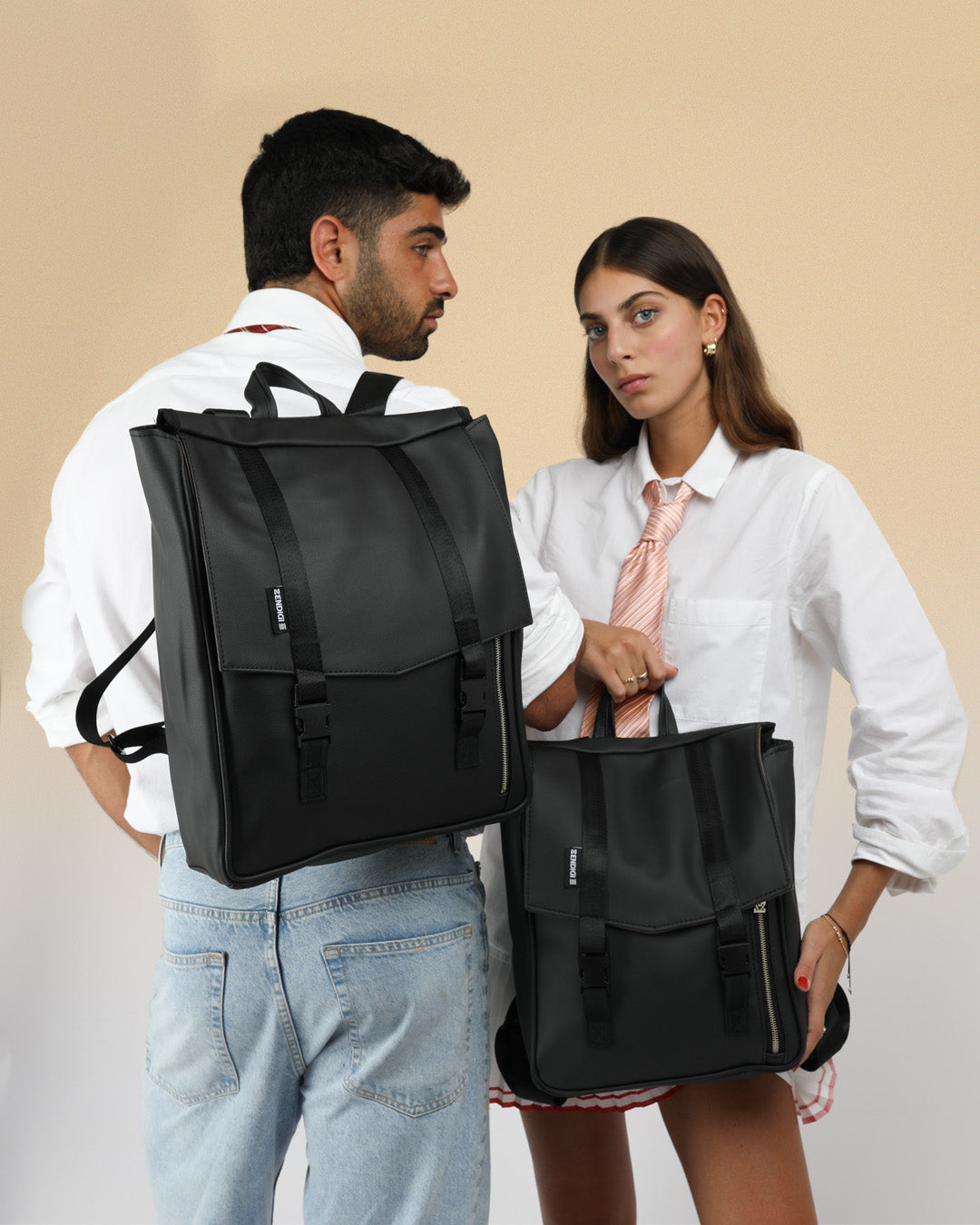 מיני טוקיו וטוקיו אחד ליד השני, הטוקיו על הבחור והמיני טוקיו מוחזק ביד של הבחורה, ניתן לראות את ההבדלים בגודל של שני התיקים שמתאימים למחשב נייד.