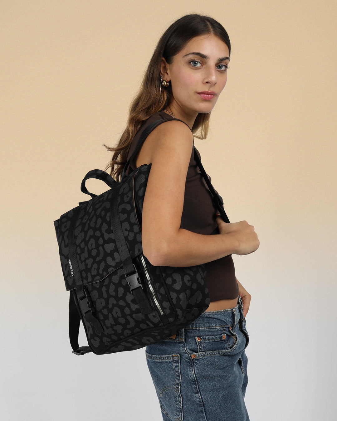 מיני טוקיו מנומר שחור, בהדפסה ידנית בסטודיו שלנו בתל אביב, תיק גב למחשב 14״ , טקסטורת נמר ייחודית לזנדיגי, תיק גב קטן למחשב, תיק גב מנומר צהוב תיק ללפטופ, תיק לאישה או לגבר, מוצג על דוגמנית