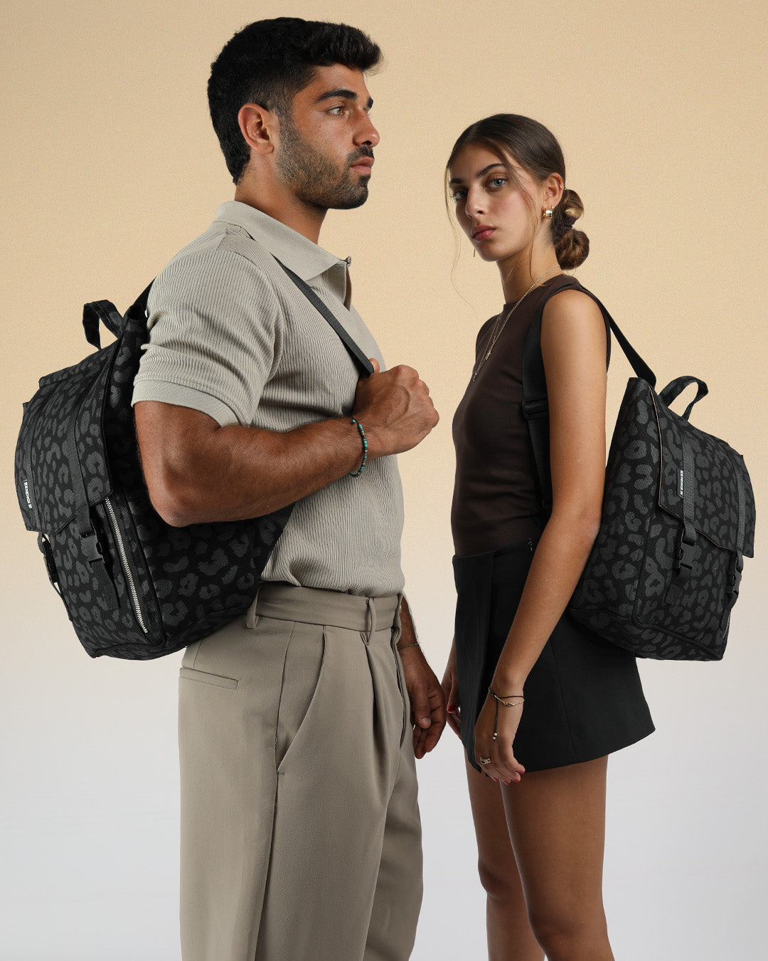 גבר ואישה עם תיק גב מיני טוקיו וטוקיו שחור מנומר, הגבר עם התיק הגדול והאישה עם הקטן, שני התיקים הם למחשב בהדפס מנומר שחור אקסקלוסיבי לזנדיגי, תיק איכותי שמחזיק מעמד שנים קדימה