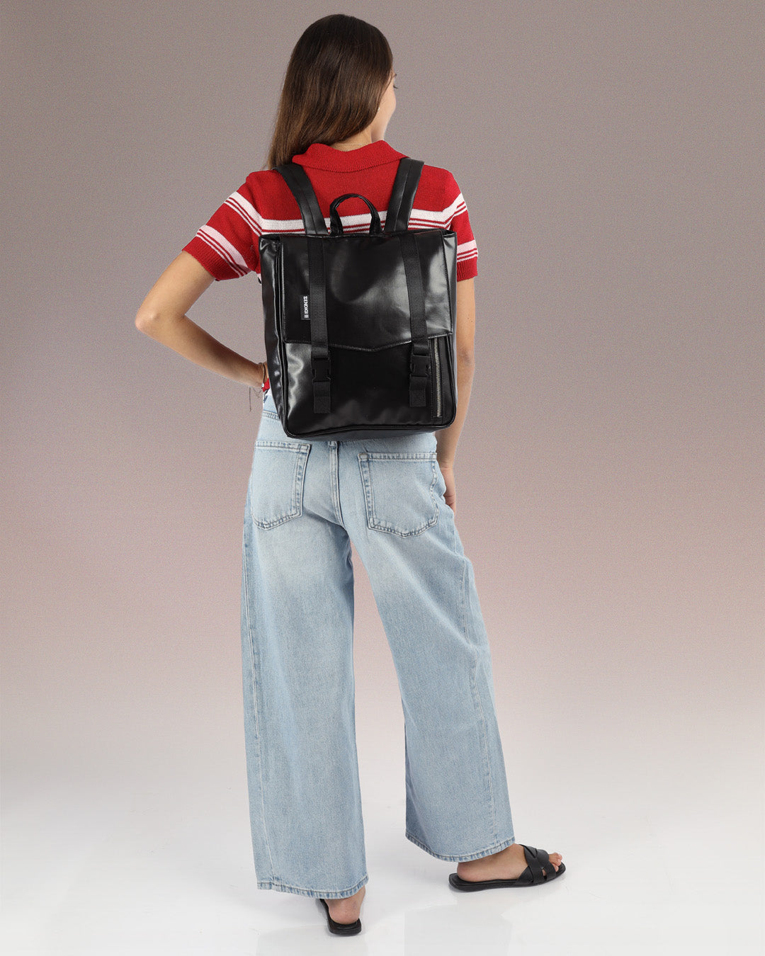 מיני טוקיו שחור מבריק מוצג על דוגמנית, תיק הגב המושלם למחשב, משלב באופן אולטימטיבי בין נוחות ליופי, ניתן לראות את גודל התיק ביחס לגופה של הדוגמנית