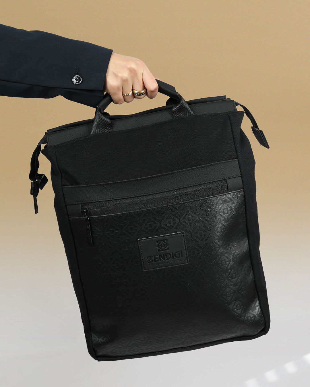 תיק גב מילאנו שחור קנבס וטוטם מבית זנדיגי, מוחזק ביד על ידי דוגמנית.