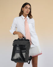 תיק גב למחשב נייד מנומר ושחור מבריק לאישה, תיק לפטופ ללימודים באוניברסיטה, תיק לסטודנטים, על דוגמנית מחזיקה את התיק ביד, ניתן לראות את הפרופורציות של התיק על הדוגמנית.