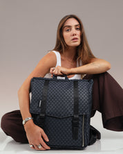 תיק גב טוקיו שחור בטקסטורת כוורת - תיק מחשב 16 אינץ' במראה אלגנטי ונוח, מושלם ללוק יומיומי, נסיעות עירוניות, עבודה ולימודים מוצג על דוגמנית בישיבה