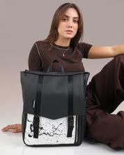 תיק מחשב נייד טוקיו שחור דלמטי מוצג על דוגמנית שיושבת על הרצפה, מוצג בצורה פרונטלית - תיק גב ללפטופ, תיק גב לסטודנטים חזק ואיכותי