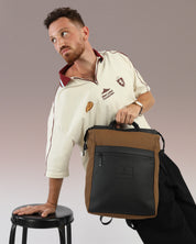 מילאנו חום ושחור - תיק גב למחשב טבעוני של זנדיגי מוחזק בידיות הנשיאה שלו על ידי דוגמן.