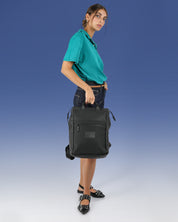 תיק גב למחשב שחור לאישה, תיק לפטופ ללימודים באוניברסיטה, תיק לסטודנטים, על דוגמנית מחזיקה את התיק ביד, ניתן לראות את הפרופורציות של התיק על הדוגמן.