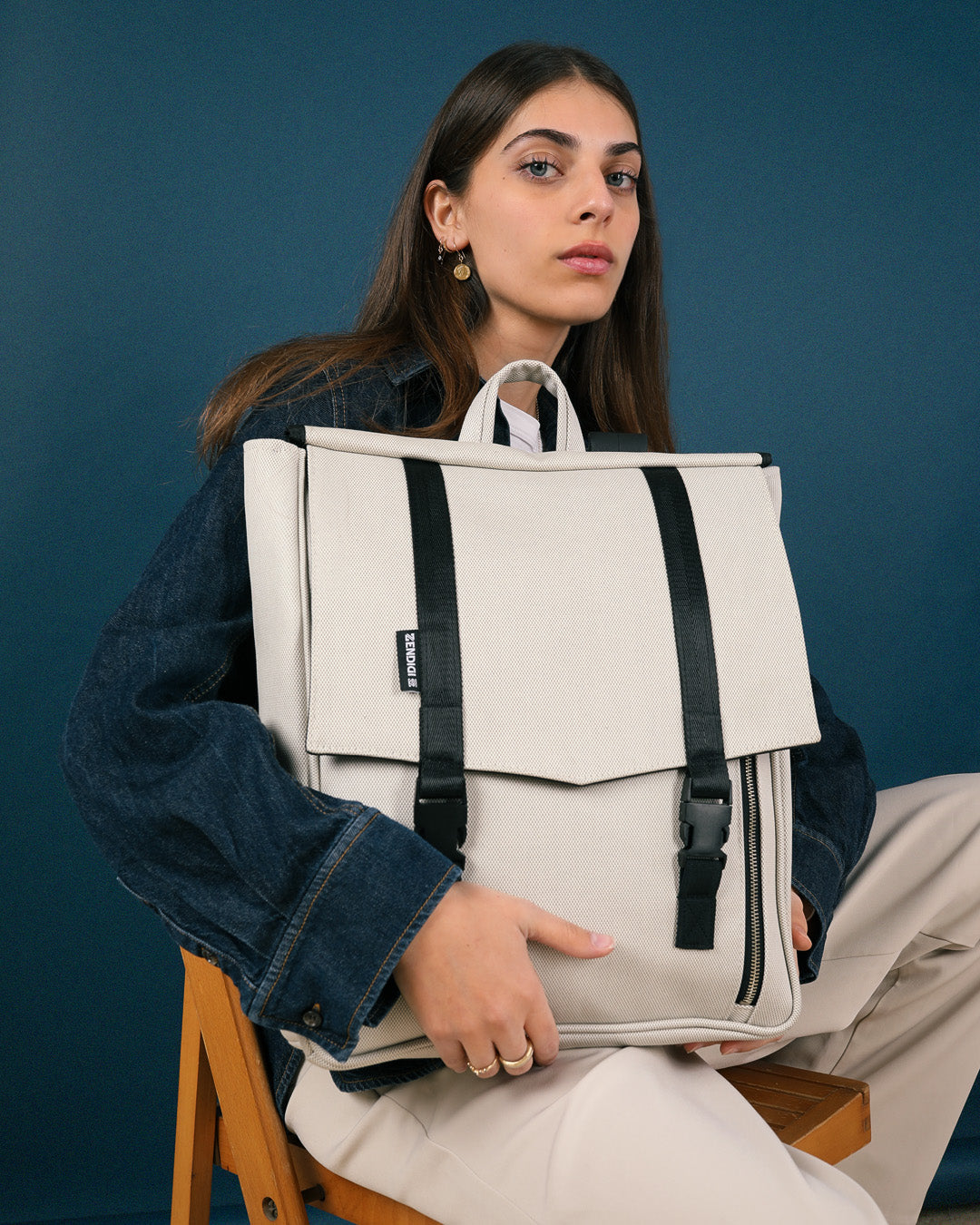 תיק גב טוקיו בינגו שמנת על גב של דוגמנית, תיק טבעוני עם עיצוב פרקטי ומוקפד, מתאים לגבר ולאישה.